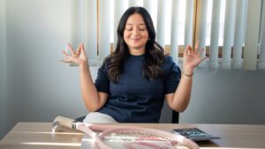Anna Scelza in posa da yoga seduta ad una scrivania